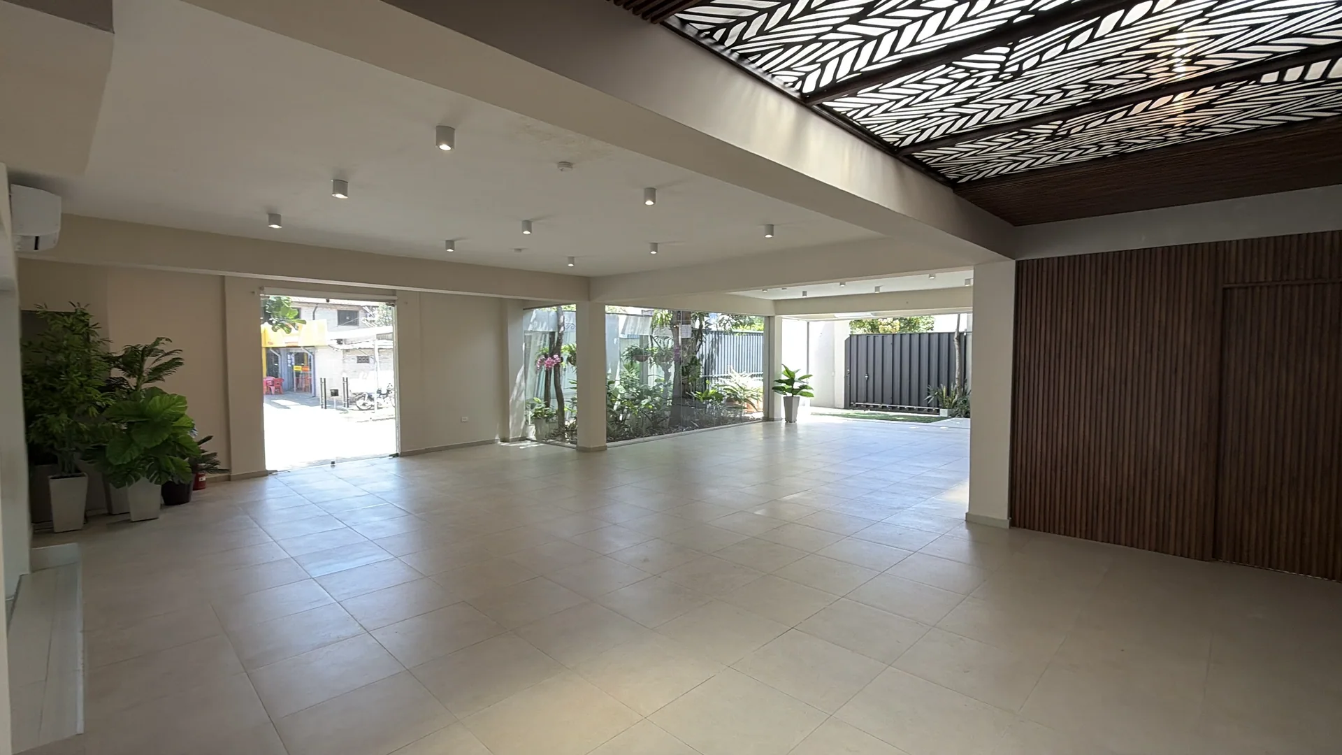 Salón con ventanales al jardín y detalles en madera calada